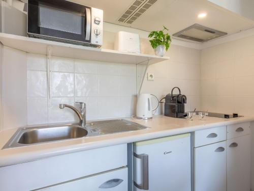 une cuisine avec un évier et un micro-ondes dans l'établissement Studio Le Tremblay by Interhome, à Cagnes-sur-Mer