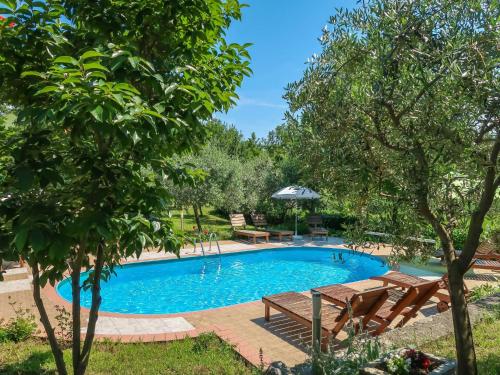 une piscine dans un jardin avec des bancs et des arbres dans l'établissement Apartment Gordana-1 by Interhome, à Labin