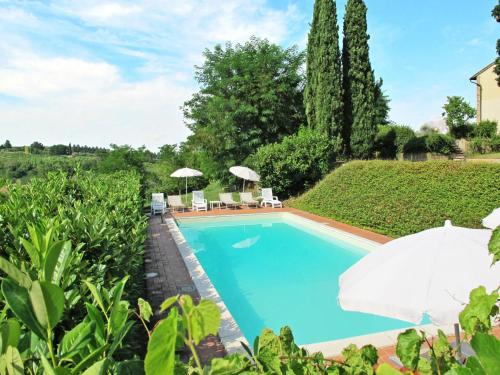 uma piscina num jardim com guarda-sóis em Holiday Home Villa Magna - Dependance by Interhome em Pian dei Cerri
