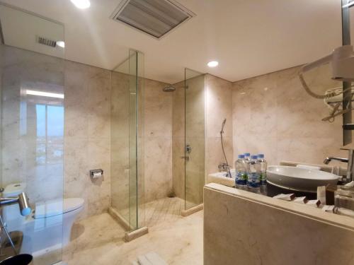 uma casa de banho com um chuveiro e um lavatório. em Best Western Plus Coco Palu em Palu