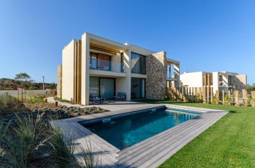 eine Villa mit einem Pool und einem Haus in der Unterkunft West Cliffs Ocean and Golf Resort in Casal da Lagoa Seca