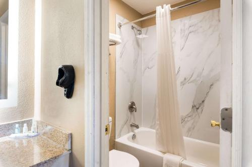 a bathroom with a marble shower curtain and a tub at Quality Inn in Gastonia