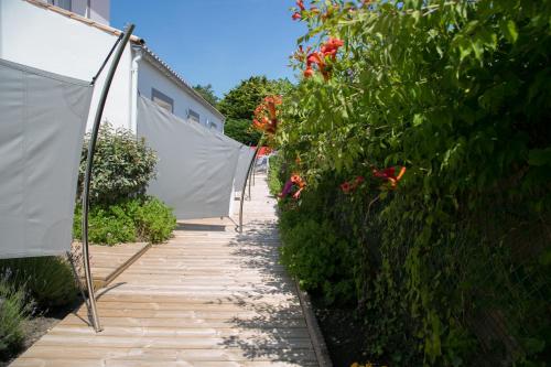 a garden path with flowering plants and a fence at La Villa en L'île - 2 Piscines & Spa in Noirmoutier-en-l'lle