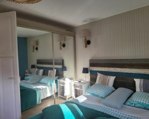 a bedroom with three beds with blue and white at BANDOL: ÉLÉGANT et COSY 2 PIÈCES, PROCHE VILLE et PLAGE in Bandol