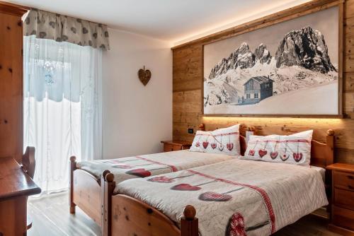 ein Schlafzimmer mit einem Bett und einem Bild an der Wand in der Unterkunft Betites Trilocale in Canazei