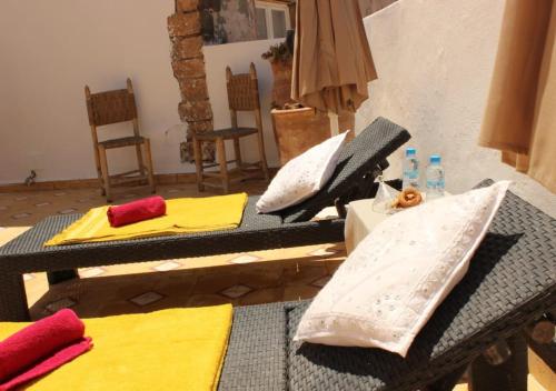 a patio with a table and chairs with umbrellas at Riad de charme l'Oasis d'Essaouira - Suite Luxe in Essaouira