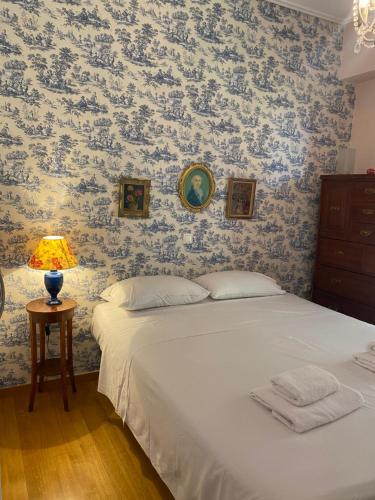 a bedroom with a bed and a table with a lamp at Traditional And Spacious Apartment In Neo Psychiko in Athens