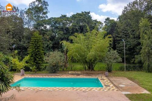einen Pool in einem Garten mit Bäumen in der Unterkunft Abby Studio Apartment with Swimming Pool in Nanyuki