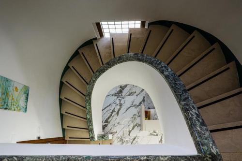 a spiral staircase in a building with an archway at RobHouse in Passo Corese