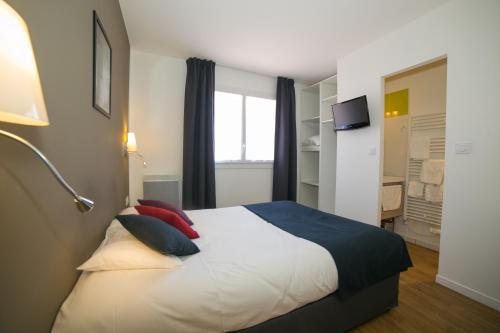 a bedroom with a large bed with red pillows at La Villa en L'île - 2 Piscines & Spa in Noirmoutier-en-l'lle