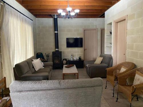 a living room with a couch and a fireplace at Stavros Country House in Siá
