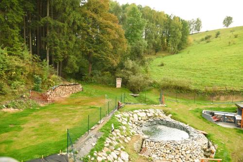 a garden with a pond in the middle of a field at Chalupa Lilien pod Medvědí skálou Jeseníky in Jindřichov