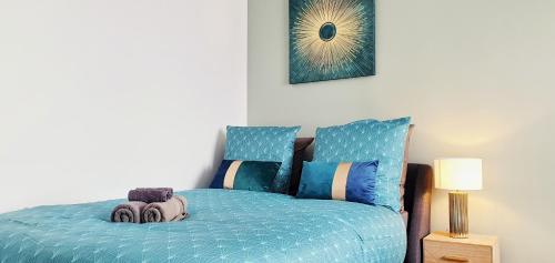 um quarto com uma cama com um edredão azul em The Sky - Dormez sur un petit nuage em Dreux