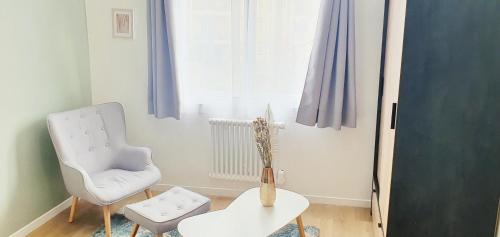 a living room with a chair and a table at The Sky - Dormez sur un petit nuage in Dreux