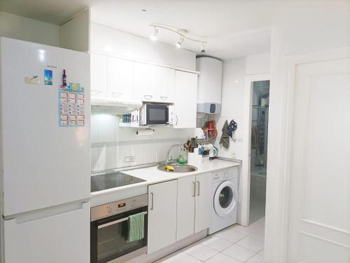 a white kitchen with a sink and a dishwasher at HABITACION EN CHUECA, CENTRO DE MADRID in Madrid