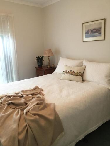 a bedroom with a large white bed with a pillow at Bird Abode in Maryborough