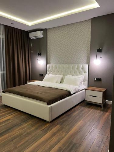 a bedroom with a large white bed and two lights at Dream Hotel in Almaty