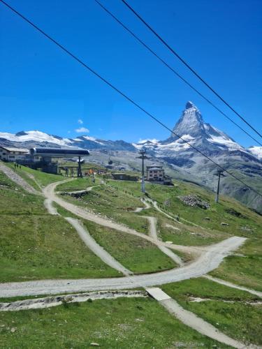a dirt road on a hill with a mountain in the background at Im alten Dorfteil von Zermatt in Zermatt