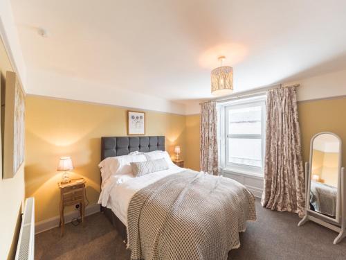 阿爾弗斯頓的住宿－Pass the Keys Cosy Cottage Nestled in the Center of Ulverston，一间卧室设有一张大床和一个窗户。