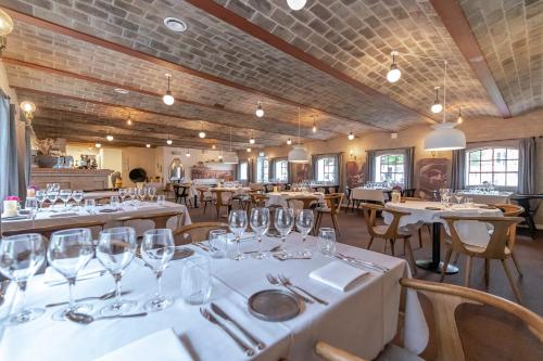 un restaurant avec des tables blanches, des chaises et des verres dans l'établissement Bramslevgaard, à Hobro