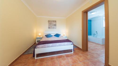 um quarto com uma cama e uma banheira num quarto em Páteo dos Oliveira - Casa da Cocheira em Évora