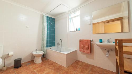 a bathroom with a tub and a toilet and a sink at Páteo dos Oliveira - Casa da Cocheira in Évora