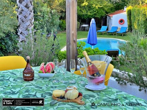 a table with a drink and a bowl of fruit on it at Casalinho da Azenha - Charm House in Sintra