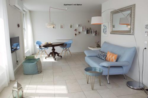 ein Wohnzimmer mit einem blauen Sofa und einem Tisch in der Unterkunft Ferienwohnungen am Theater Freiburg in Freiburg im Breisgau