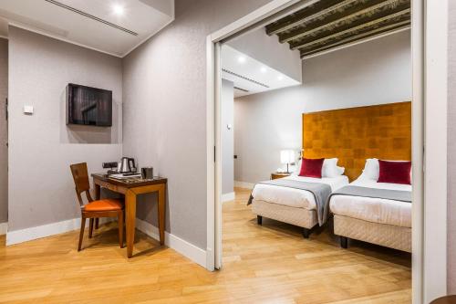 a bedroom with a bed and a desk with a chair at Hotel Delle Nazioni in Rome