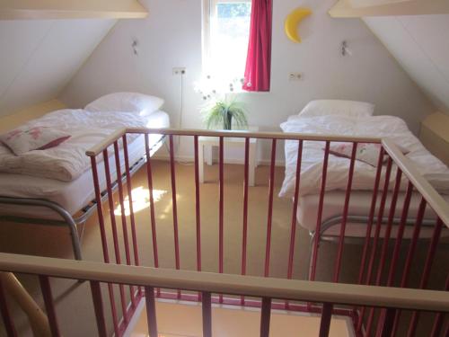 twee bedden in een kamer met een trap bij Huize Ruurlo in Ruurlo