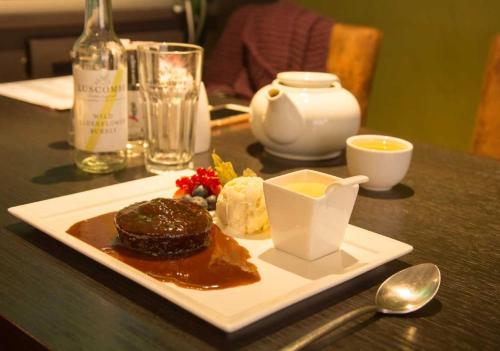 une assiette de nourriture sur une table avec un dessert dans l'établissement Bath House Hotel, à Chard