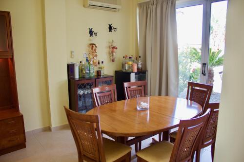 a dining room with a wooden table and chairs at Carolyn Villa is a Luxury 4-Bedroom Villa with Private Pool in Ayia Napa in Ayia Napa