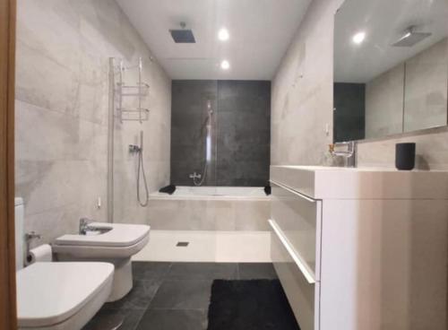 y baño con aseo, lavabo y bañera. en Loft Miramar en Fuengirola