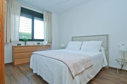 Un dormitorio blanco con una cama grande y una ventana. en Loft Miramar, en Fuengirola