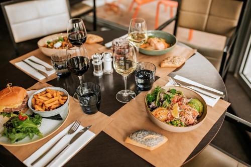 a table with plates of food and glasses of wine at B&B HOTEL Lyon Nord 4 étoiles in Dardilly