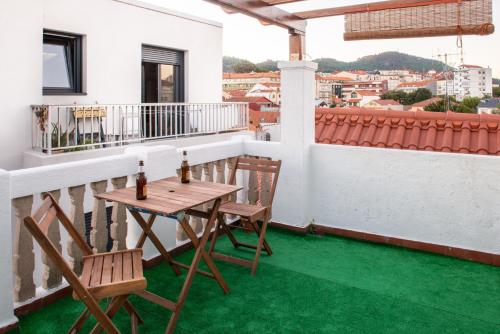 - Balcón con suelo verde, mesa y sillas en Cerca del puerto deportivo y de la playa, en Cangas de Morrazo