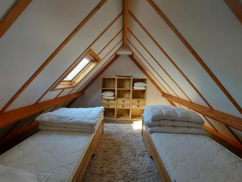 Cette chambre mansardée comprend 2 lits et une fenêtre. dans l'établissement Casa Nieuwendamme, à Nieuport