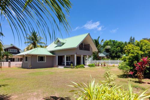a house with a green roof and a yard at The Garden Villas - La Digue in La Digue