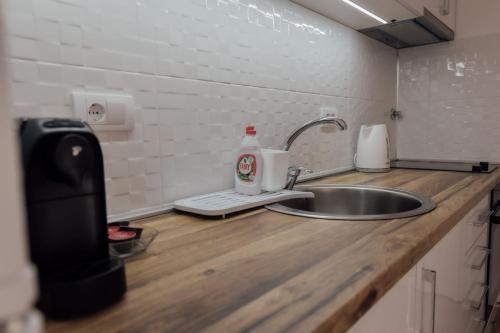 a kitchen counter with a sink and a soap dispenser at La Casa M in Vršac
