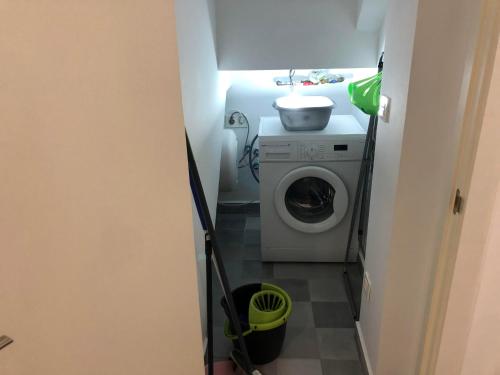 a small bathroom with a washing machine and a sink at Casita Mondoto, encanto en el Pirineo in Frajén