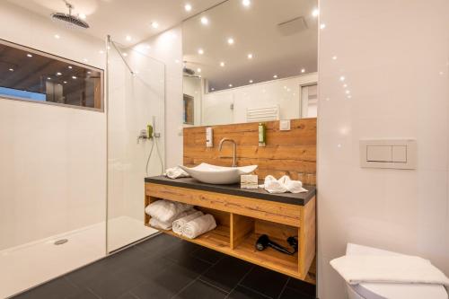 a bathroom with a sink and a shower at Promenaden-Strandhotel Marolt in Sankt Kanzian