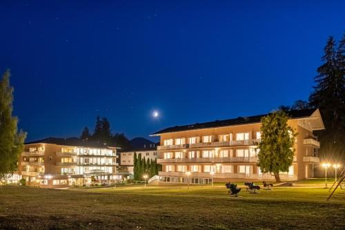 a building at night with the moon in the sky at Promenaden-Strandhotel Marolt in Sankt Kanzian