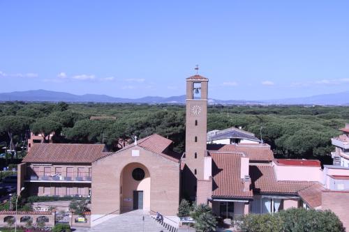 a church with a clock tower in a town at Residence Mediterraneo in Marina di Grosseto
