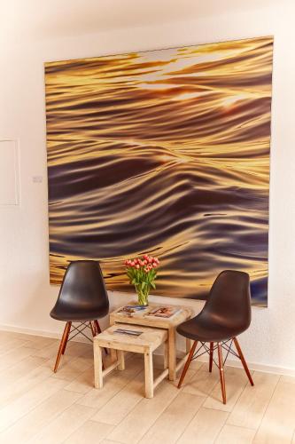 two chairs and a coffee table in front of a painting at Schlei Hotel in Kappeln