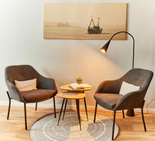 two chairs and a table and a lamp in a room at Schlei Hotel in Kappeln