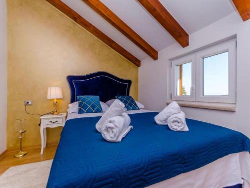 a bedroom with a blue bed with towels on it at Villa Antica in Ražanj