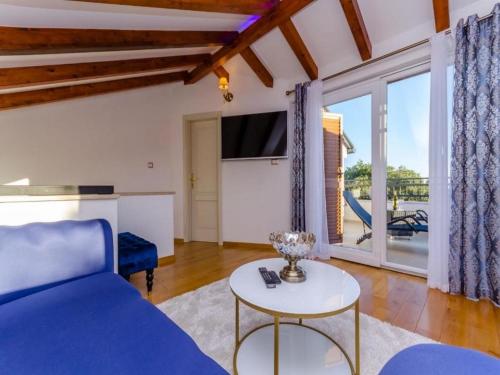 - un salon avec un canapé bleu et une table dans l'établissement Villa Antica, à Ražanj