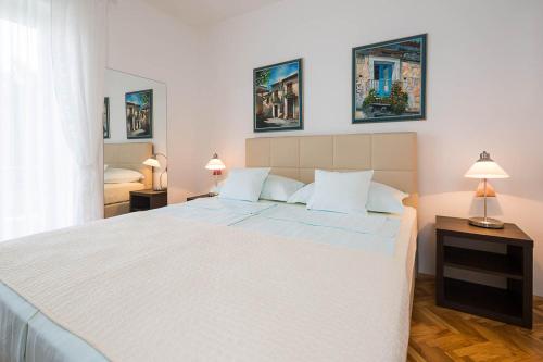 1 cama blanca grande en un dormitorio con 2 lámparas en Kazimir en Zavala
