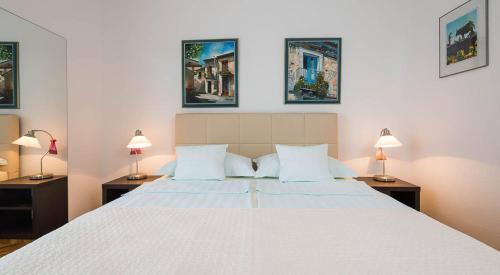 1 dormitorio con 1 cama blanca grande y 2 lámparas en Kazimir en Zavala