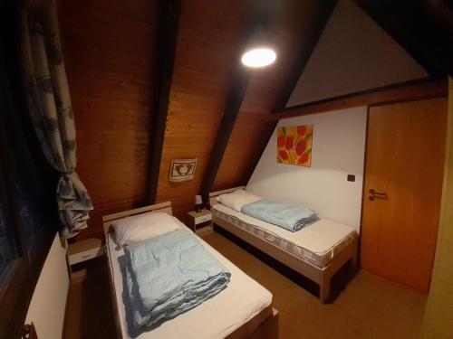 een kleine kamer met 2 bedden in een huis bij Ferienhaus Kornblume in Ronshausen